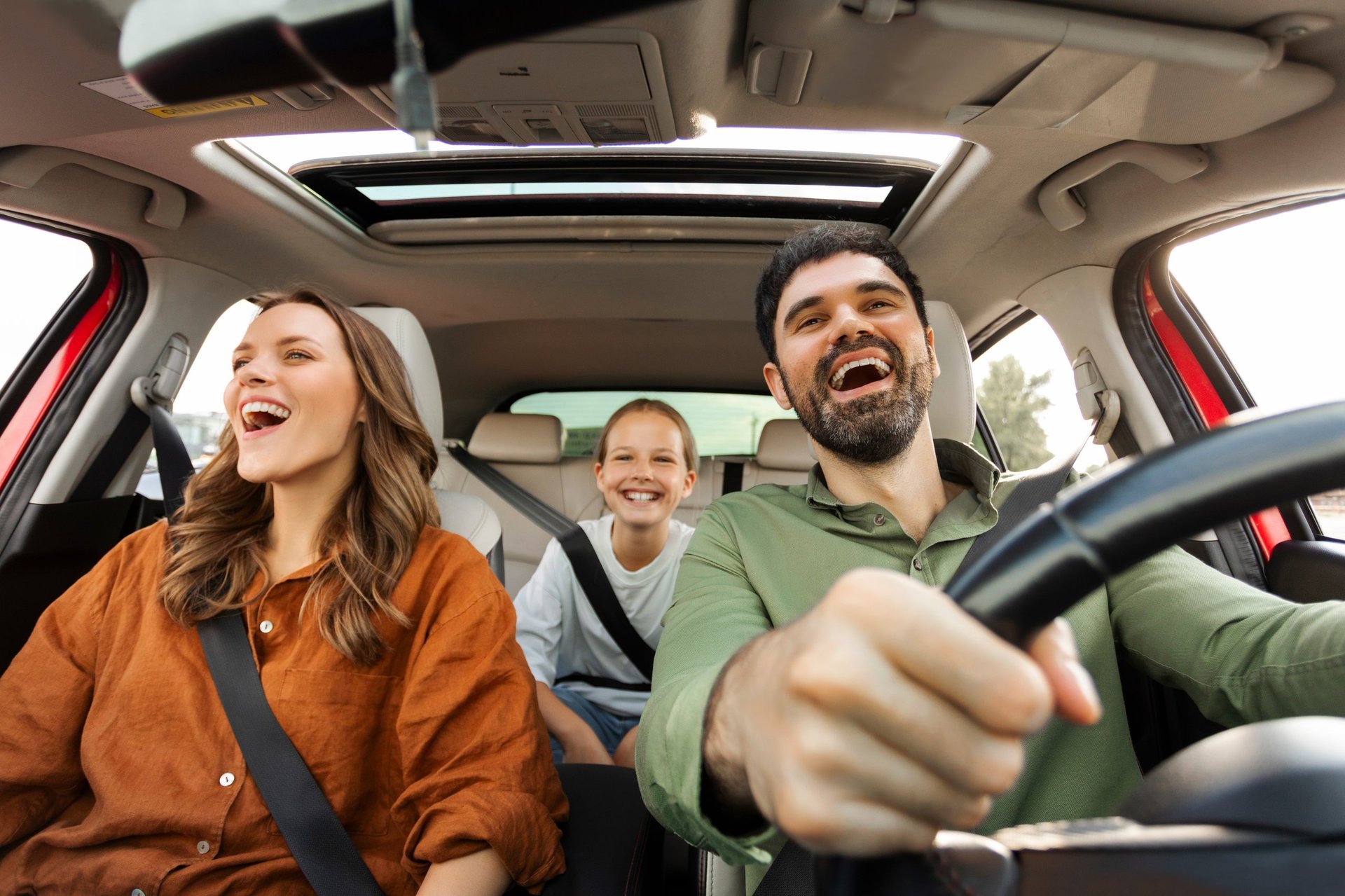 Joyful family riding in car together on a road trip