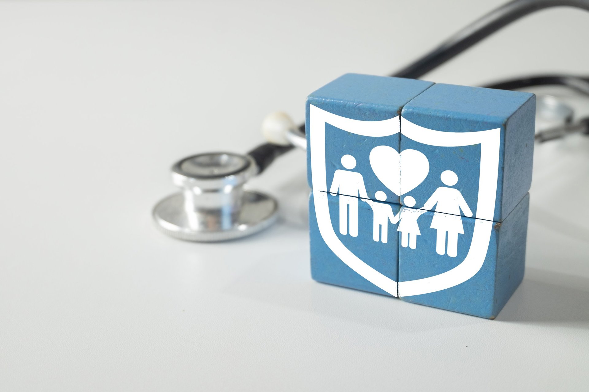 Family health insurance icon on wooden blocks with stethoscope